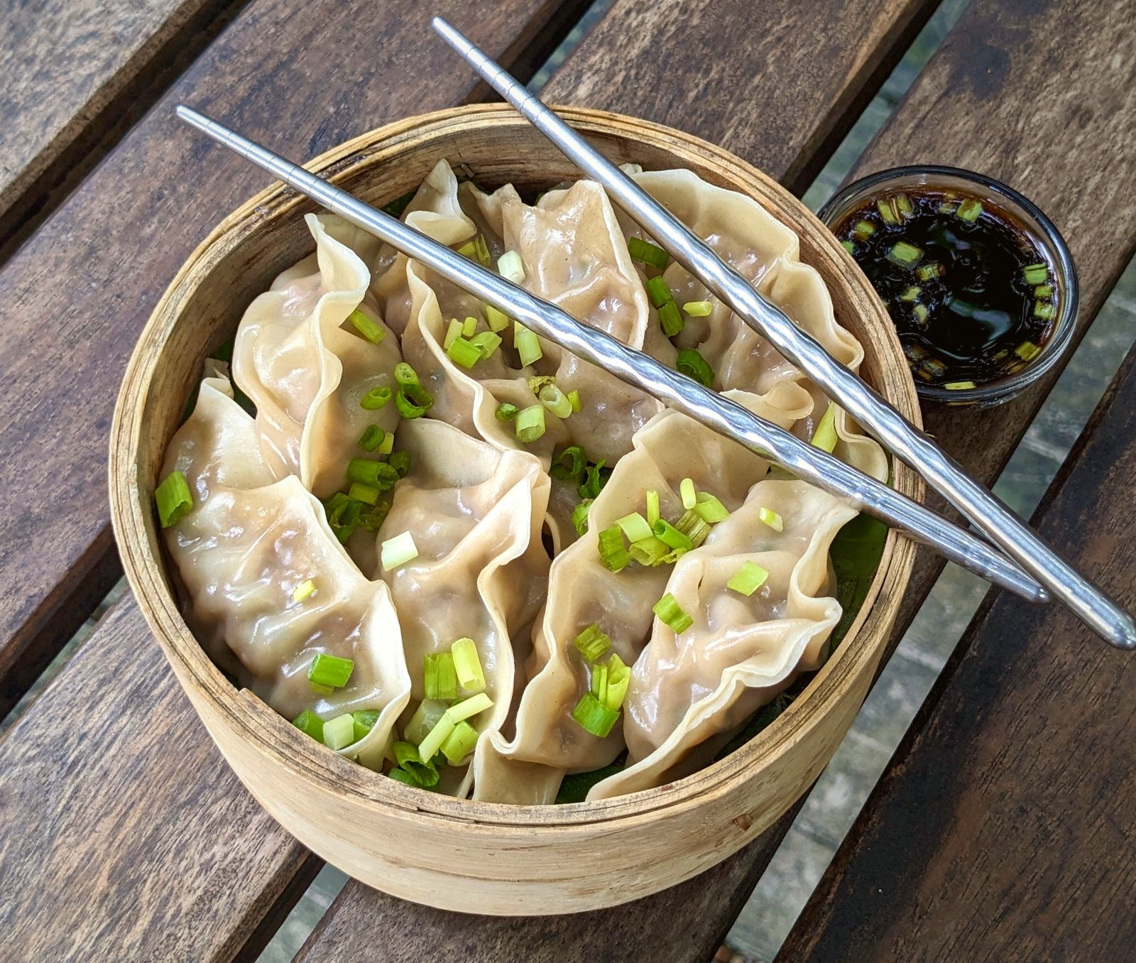 Steamed pork dumplings in a bamboo basket with chopsticks and chilli soy at Vinya Garden Colombo